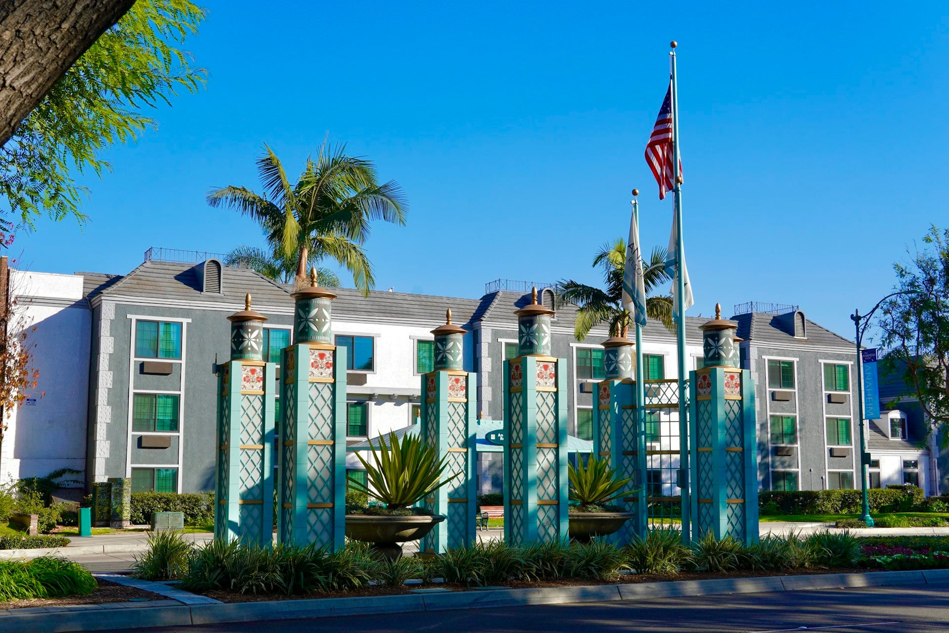 Art Deco columns and palm trees in Anaheim entertainment district with American flag