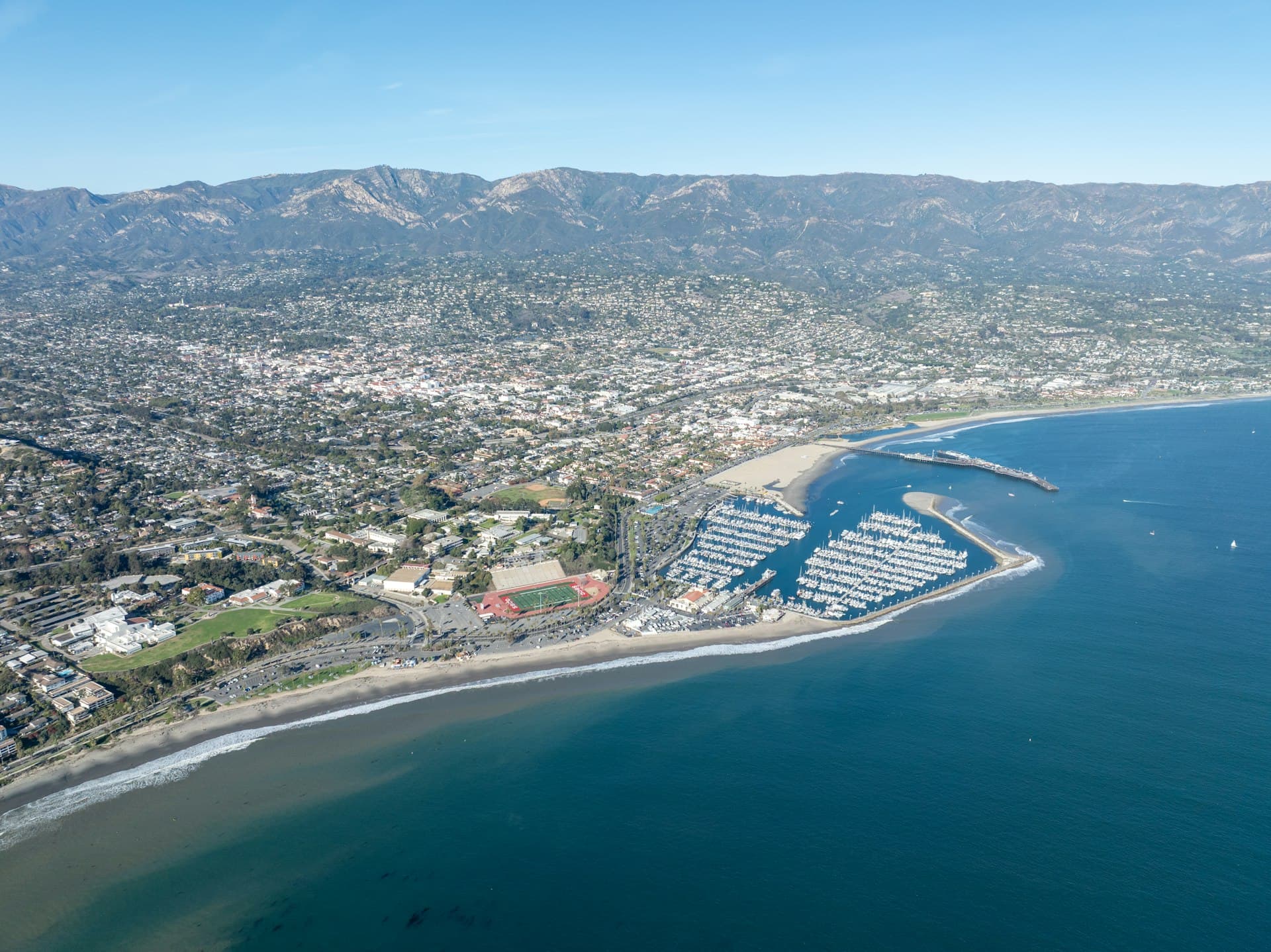 Aerial view of Orange County California coastal town with marina and mountains