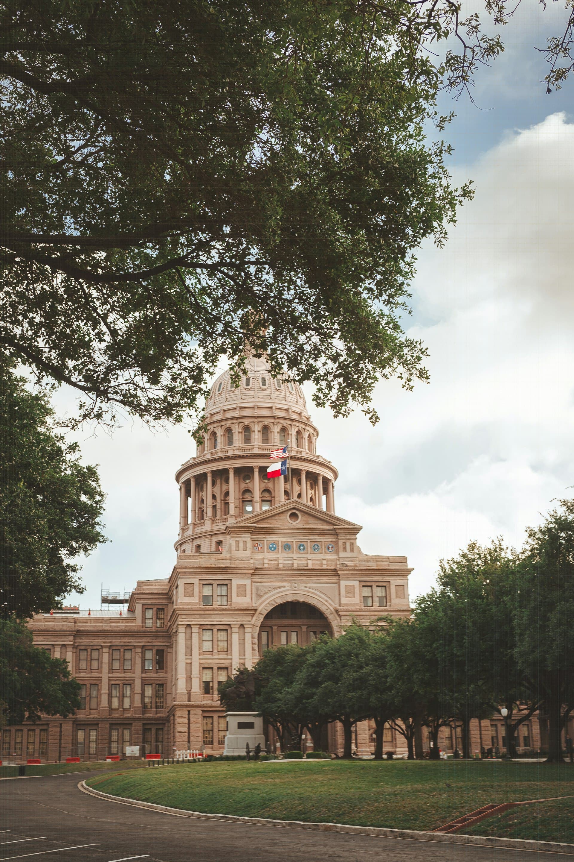 Texas State Capitol building in Austin framed by trees on Congress Avenue