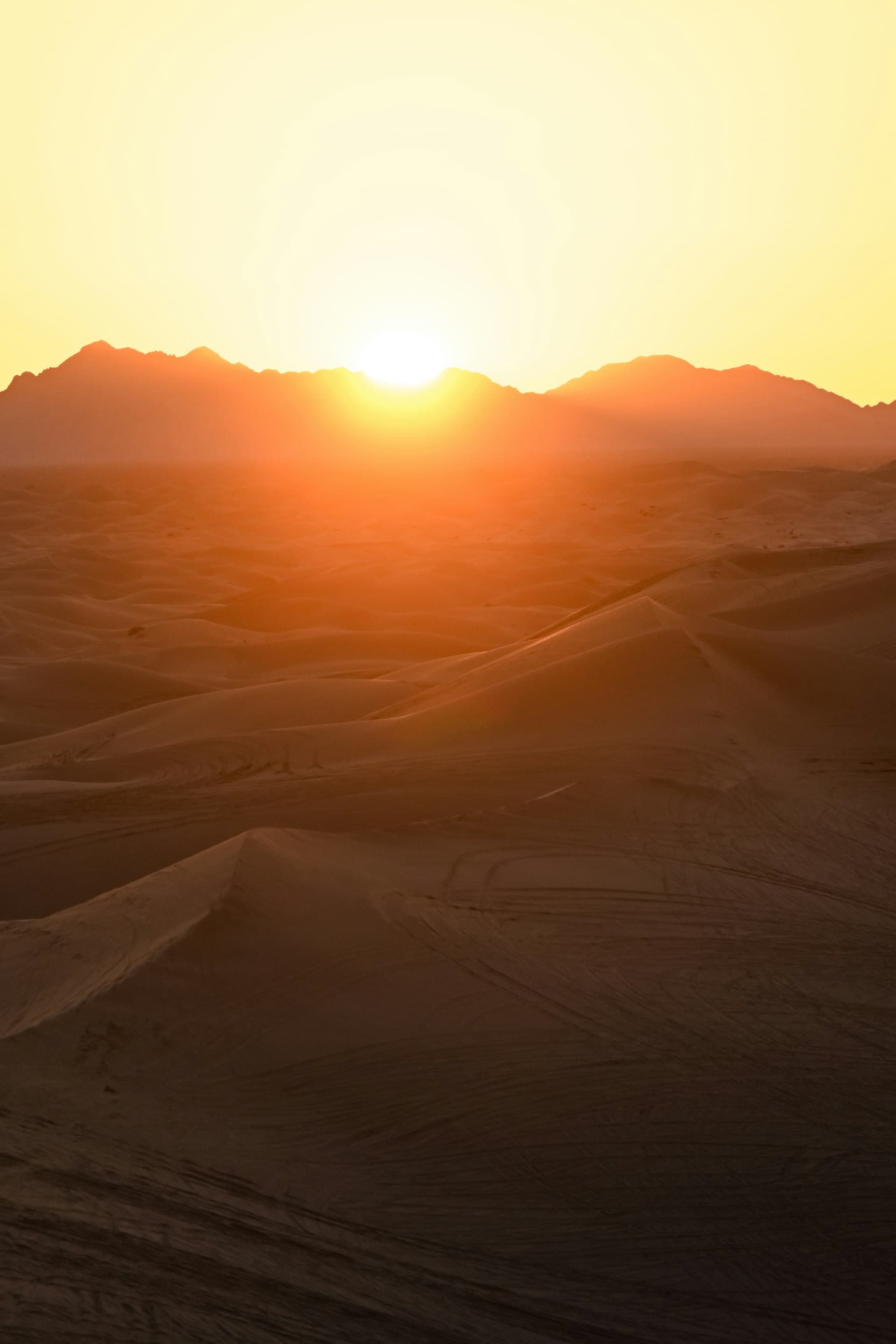 Desert sunset with sand dunes and mountains representing extreme heat conditions