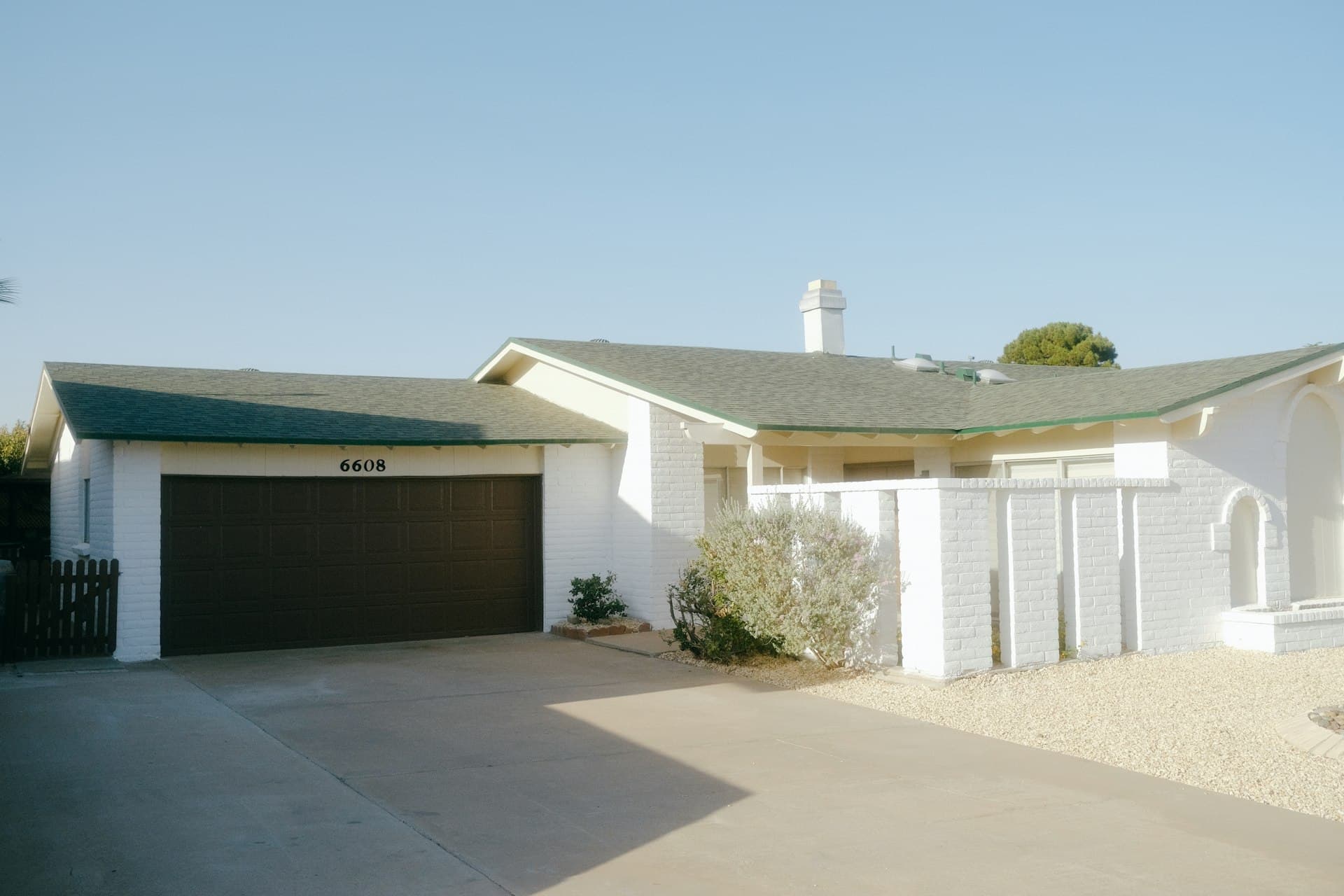 White stucco home with asphalt shingle roof in El Paso Texas