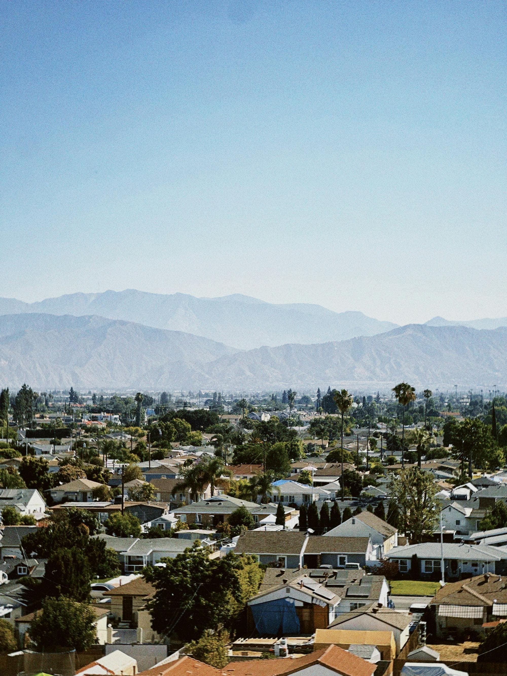Aerial view of suburban neighborhood with mountain range in background