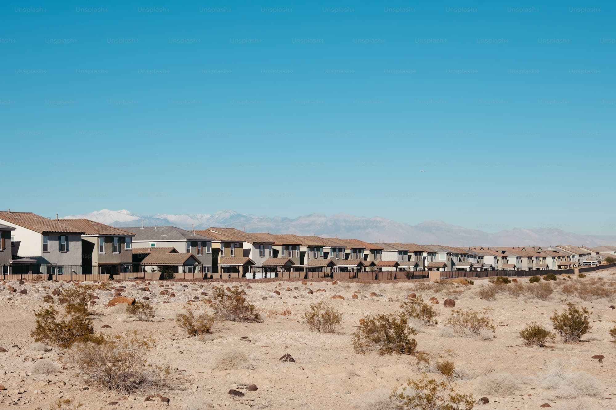 Row of new homes with tile roofs in Henderson Nevada desert with mountains