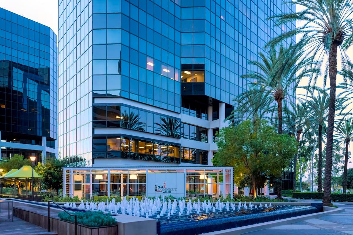 Modern glass office building with palm trees and fountain in Irvine California