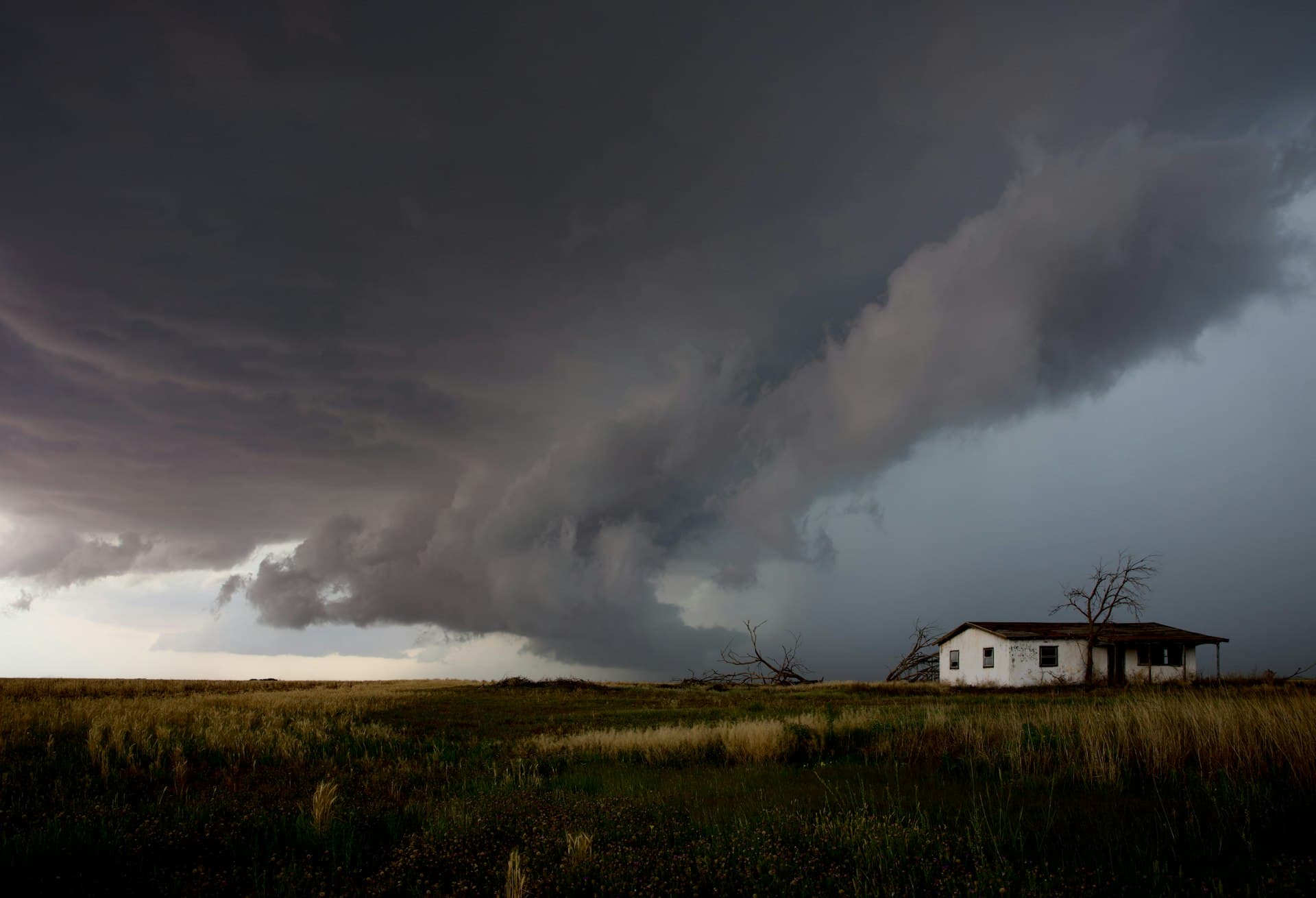 Dramatic Texas storm clouds approaching house on open landscape