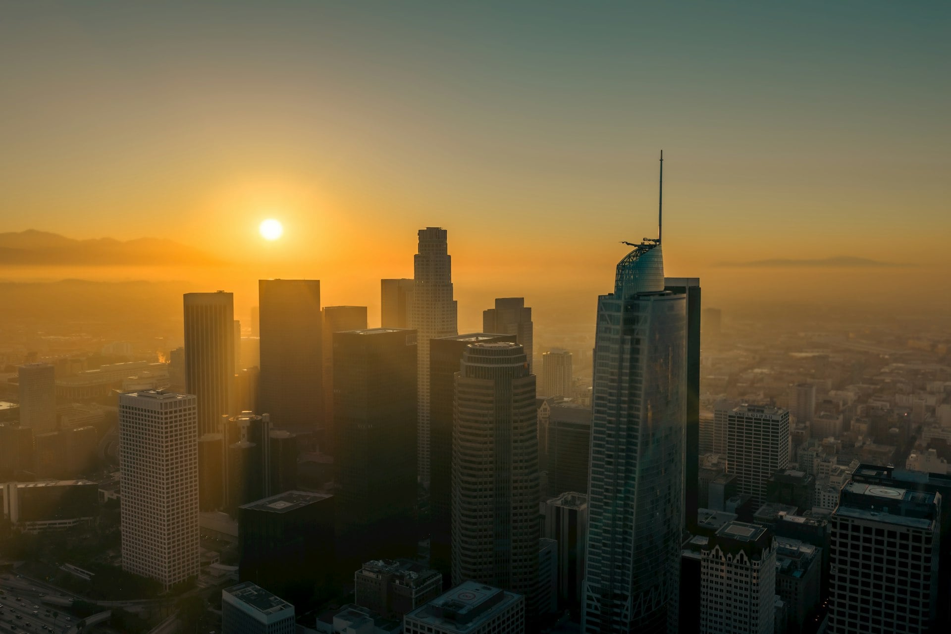 Downtown Los Angeles skyline at sunrise with skyscrapers against colorful sky