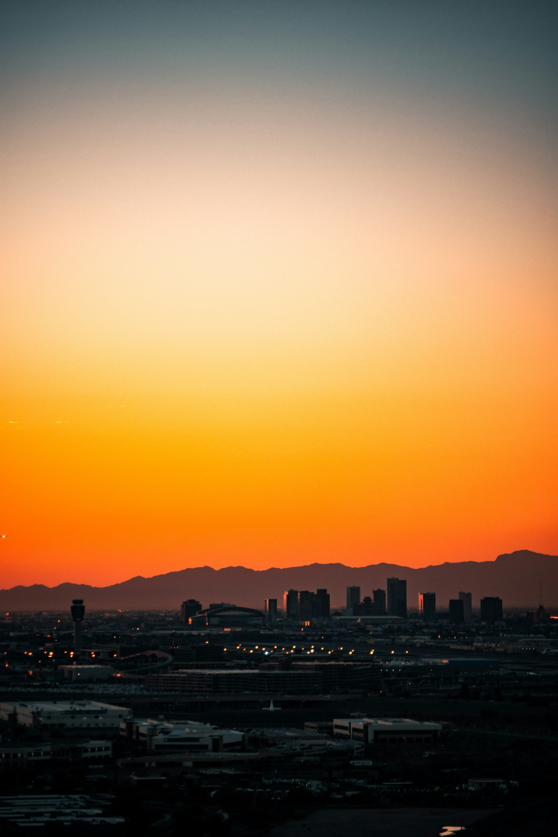 Phoenix metro skyline at sunset with mountains in the background