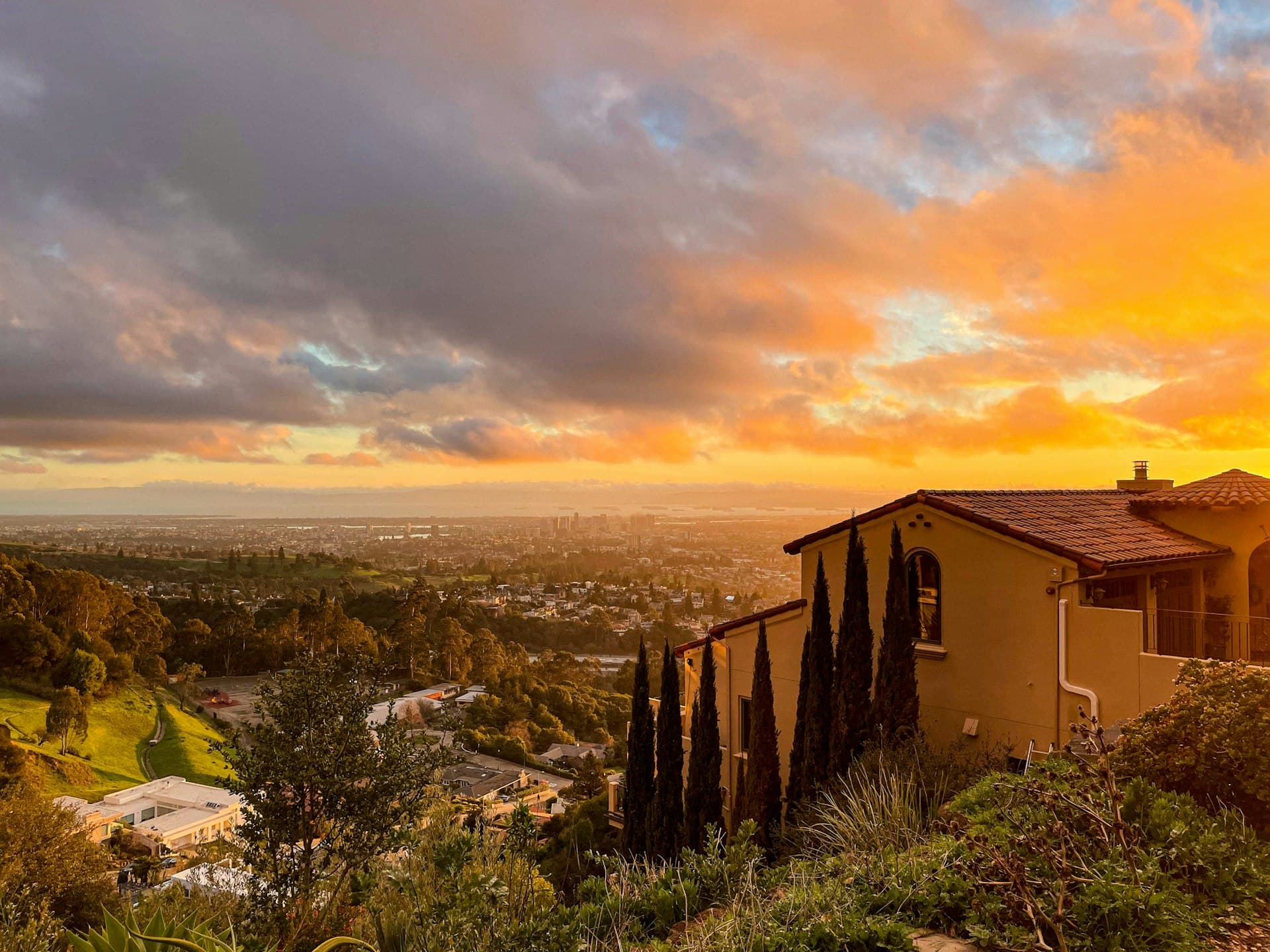 Oakland Hills home with tile roof and panoramic Bay Area view at sunset