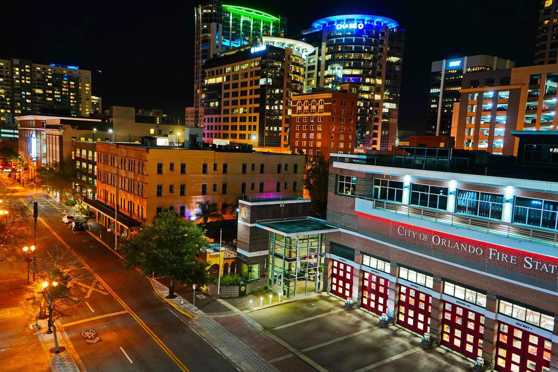 Downtown Orlando Florida cityscape at night with illuminated buildings and City of Orlando Fire Station