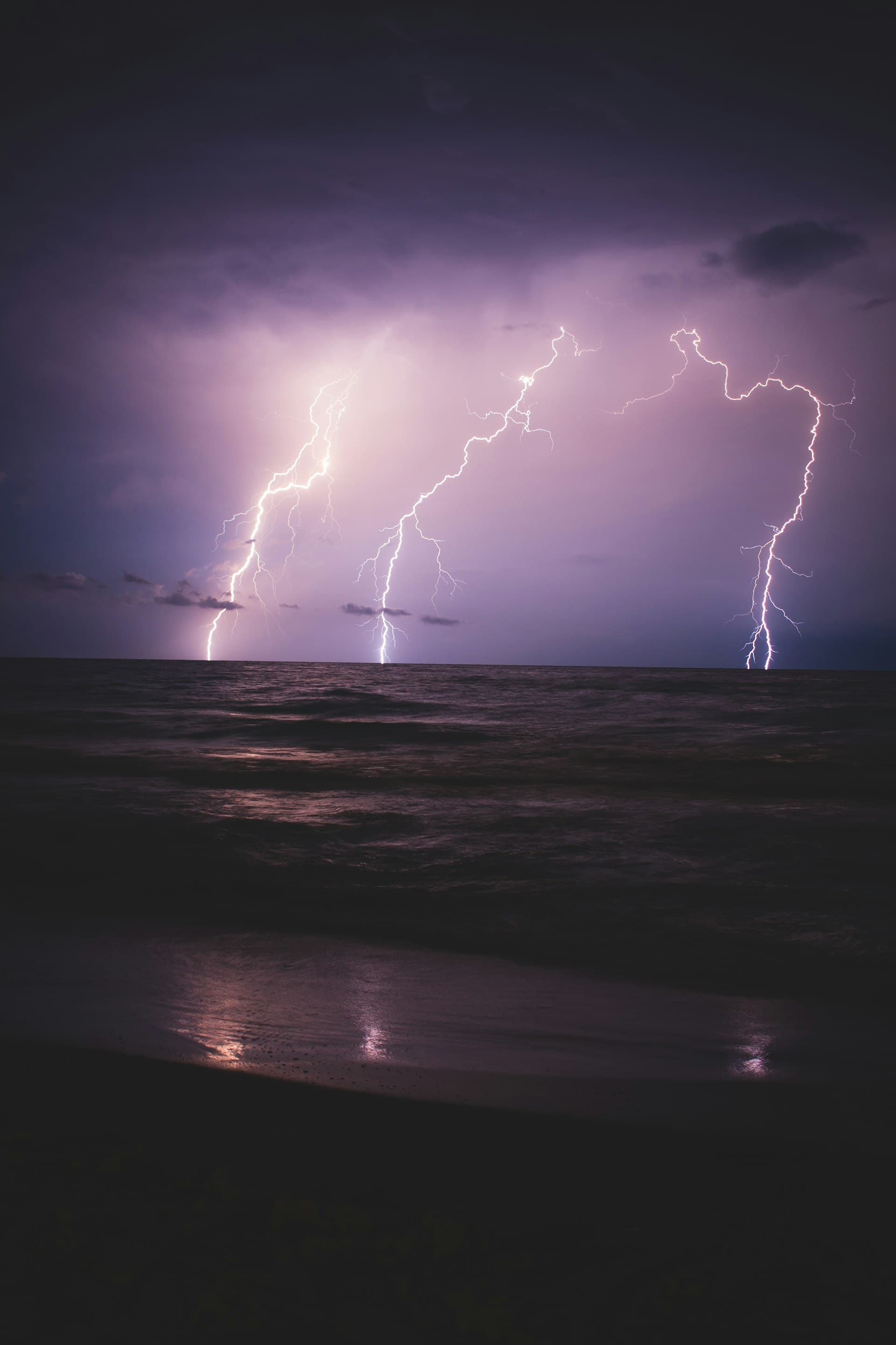 Florida tropical storm with lightning strikes over ocean at night