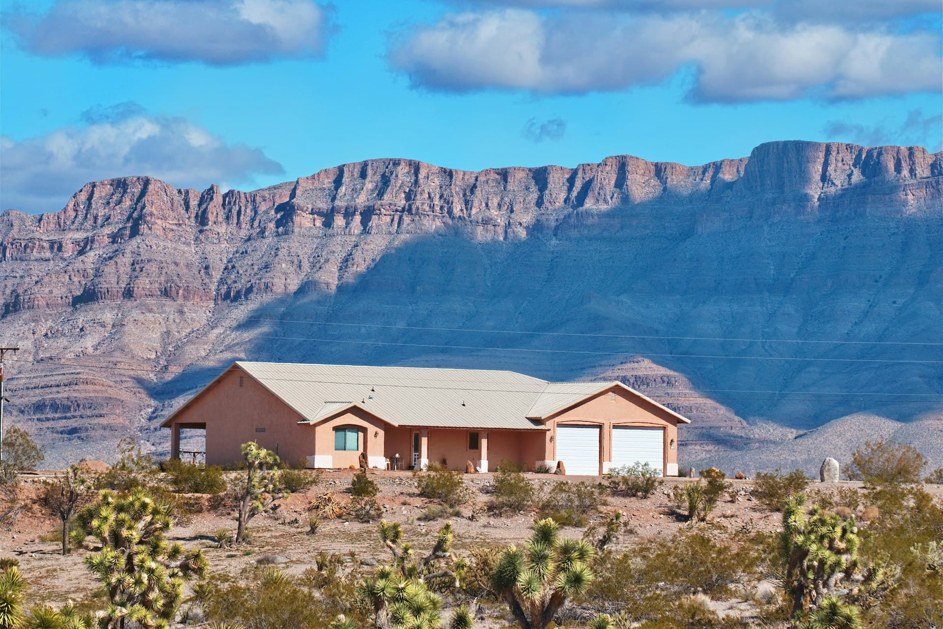 Arizona desert home with tile roof against dramatic mountain backdrop