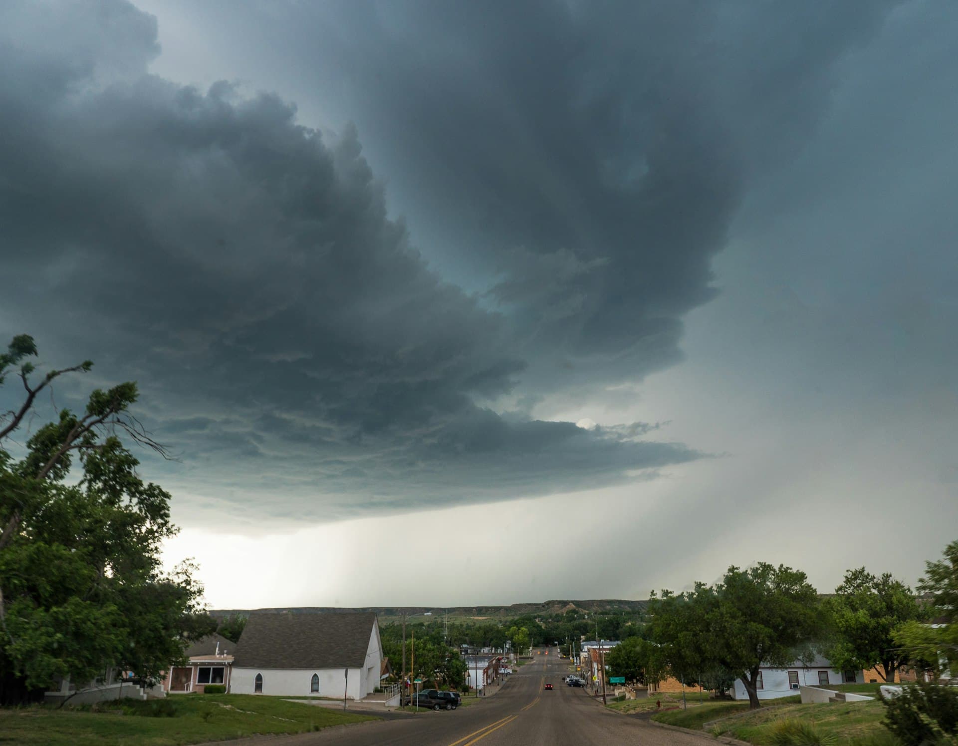 Texas supercell thunderstorm hovering over small town with dramatic storm clouds