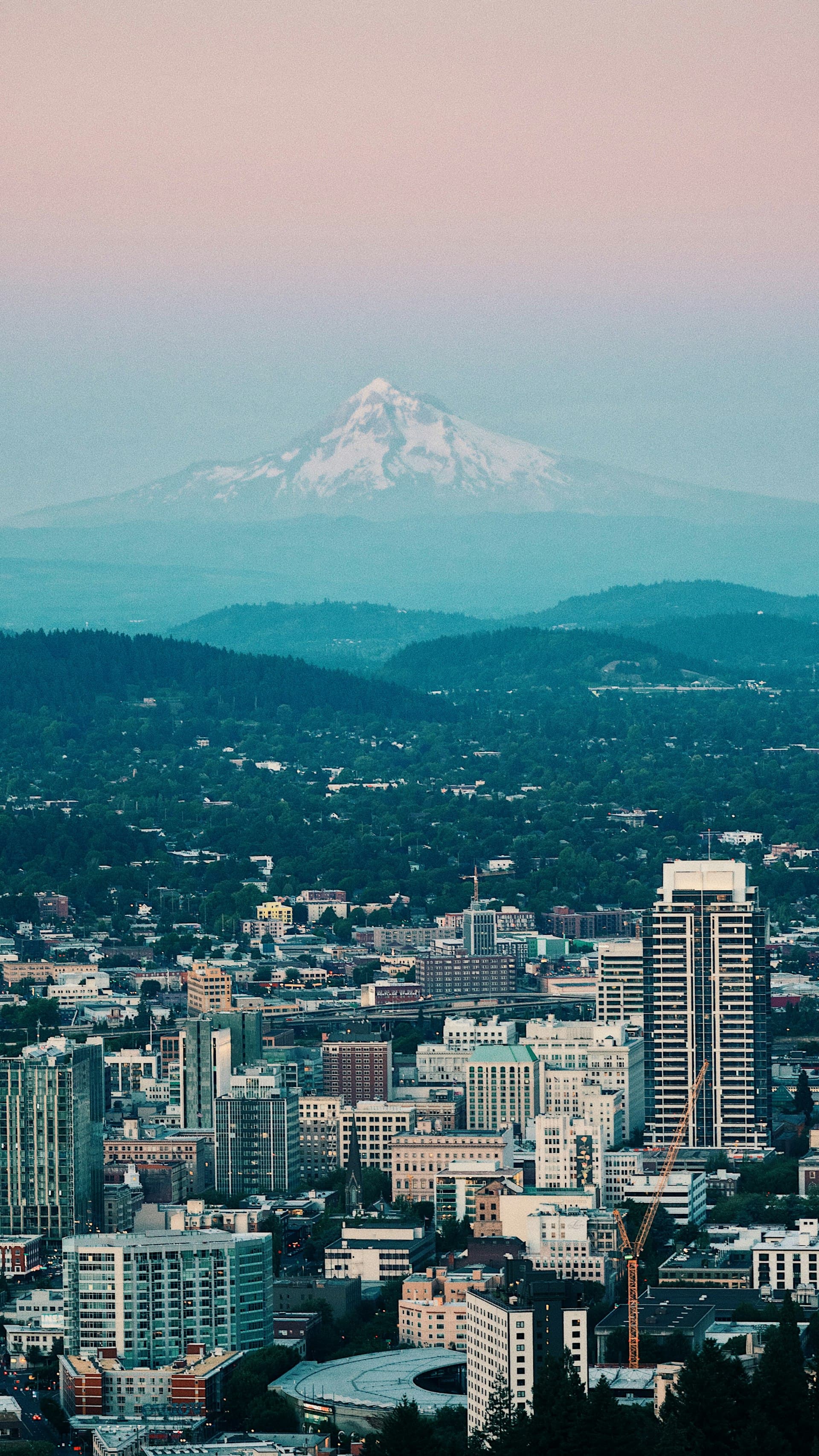 Aerial view of Portland Oregon with Mount Hood and city rooftops at sunset
