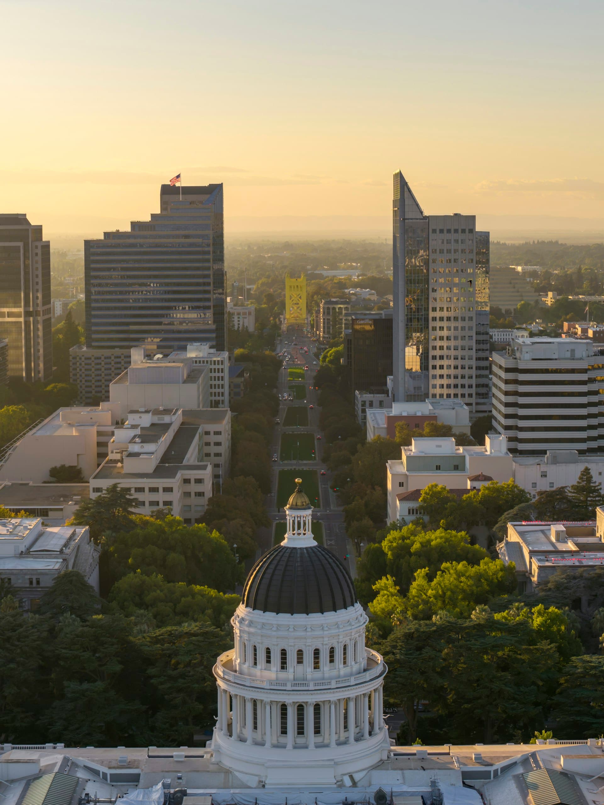 California State Capitol building dome with Sacramento skyline at sunset