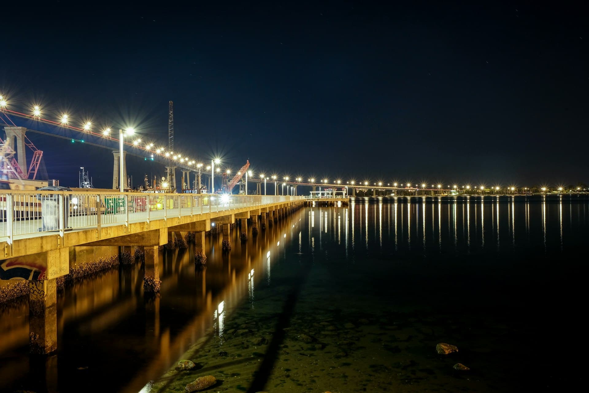 San Diego waterfront and Coronado Bridge at night with city lights reflecting on the bay