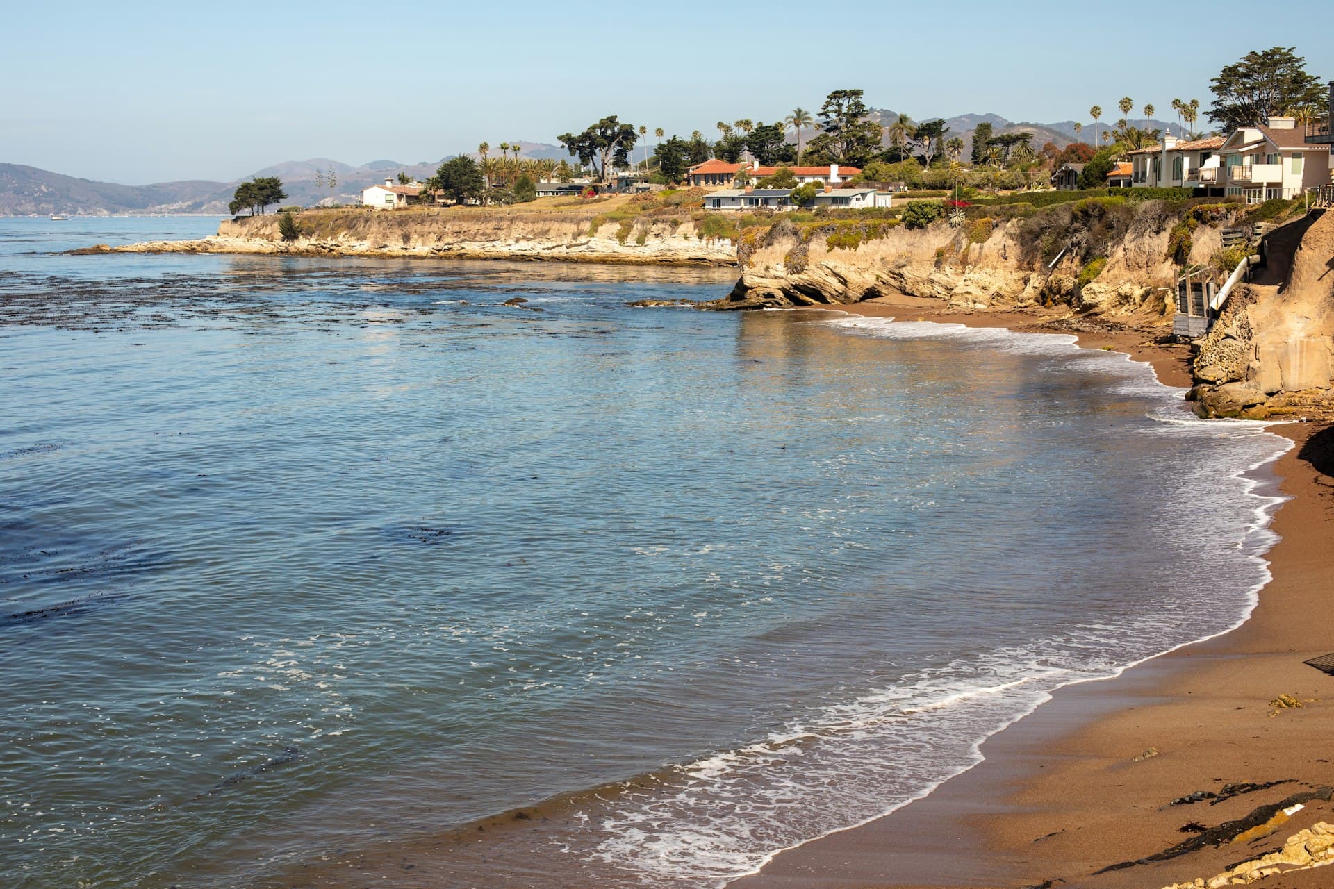 California coastal homes overlooking sandy beach and calm Pacific Ocean