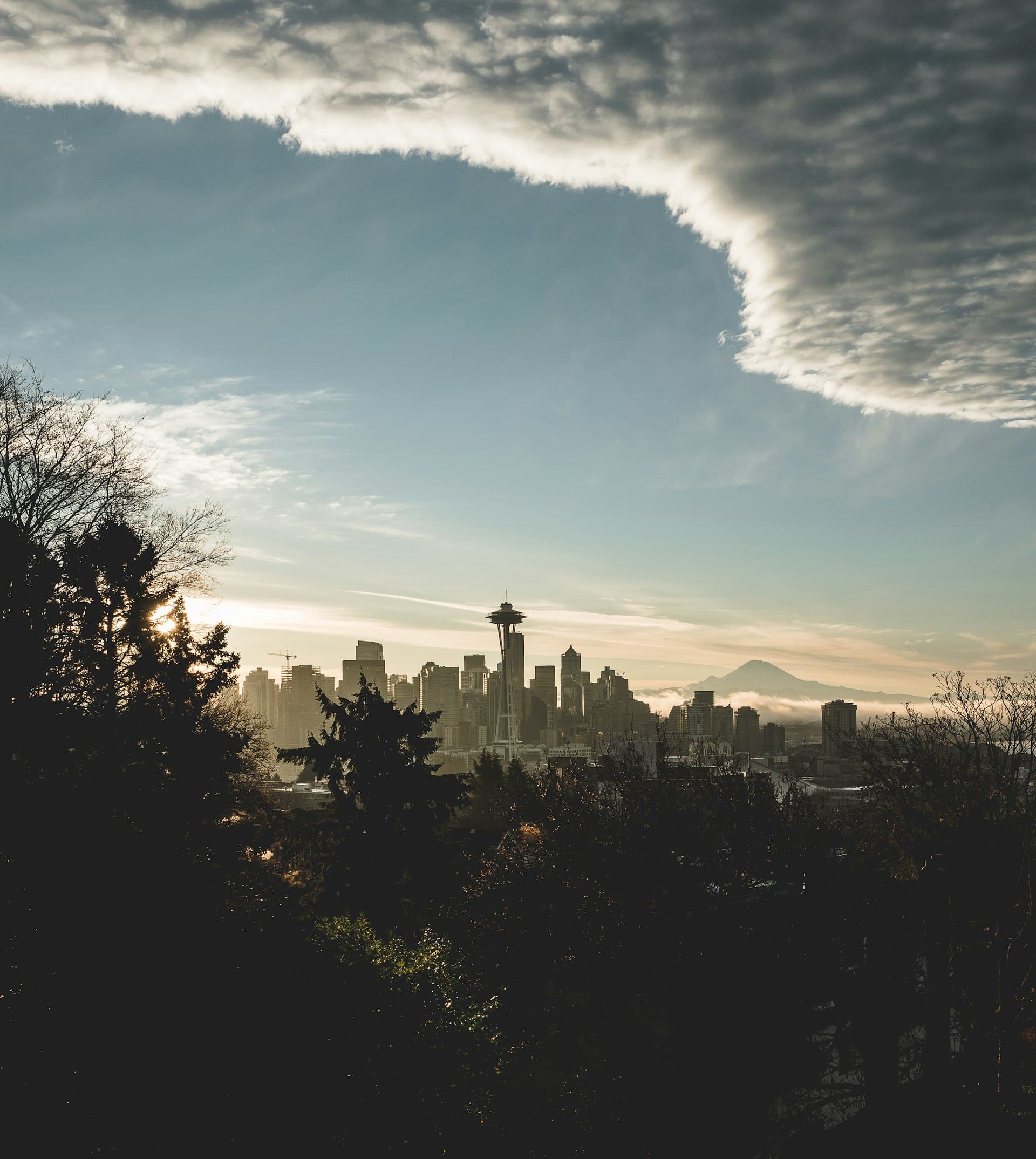 Seattle skyline with dramatic cloudy sky and Mount Rainier visible