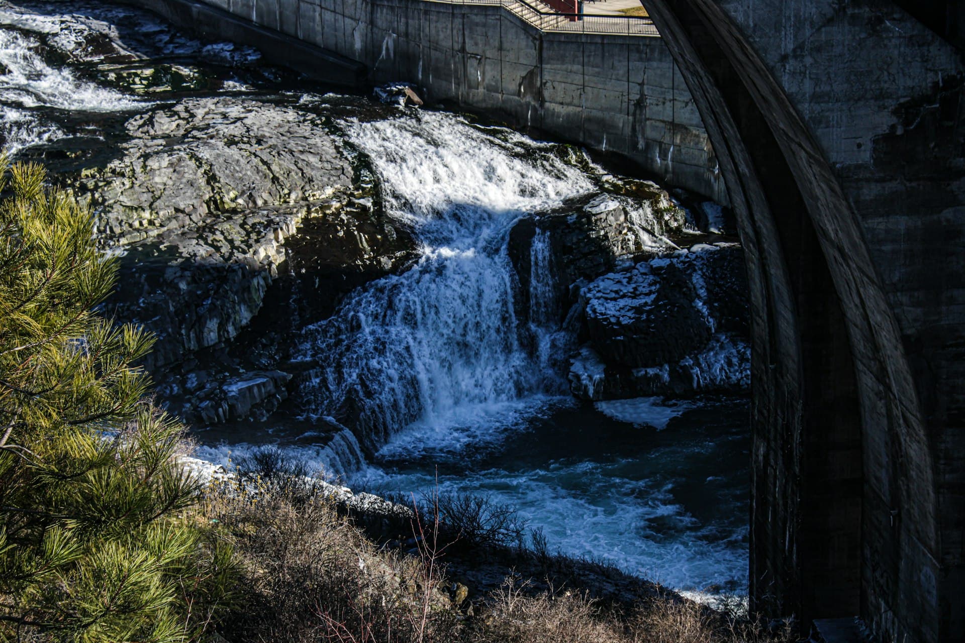 Spokane Falls waterfall cascading over dam with bridge in background