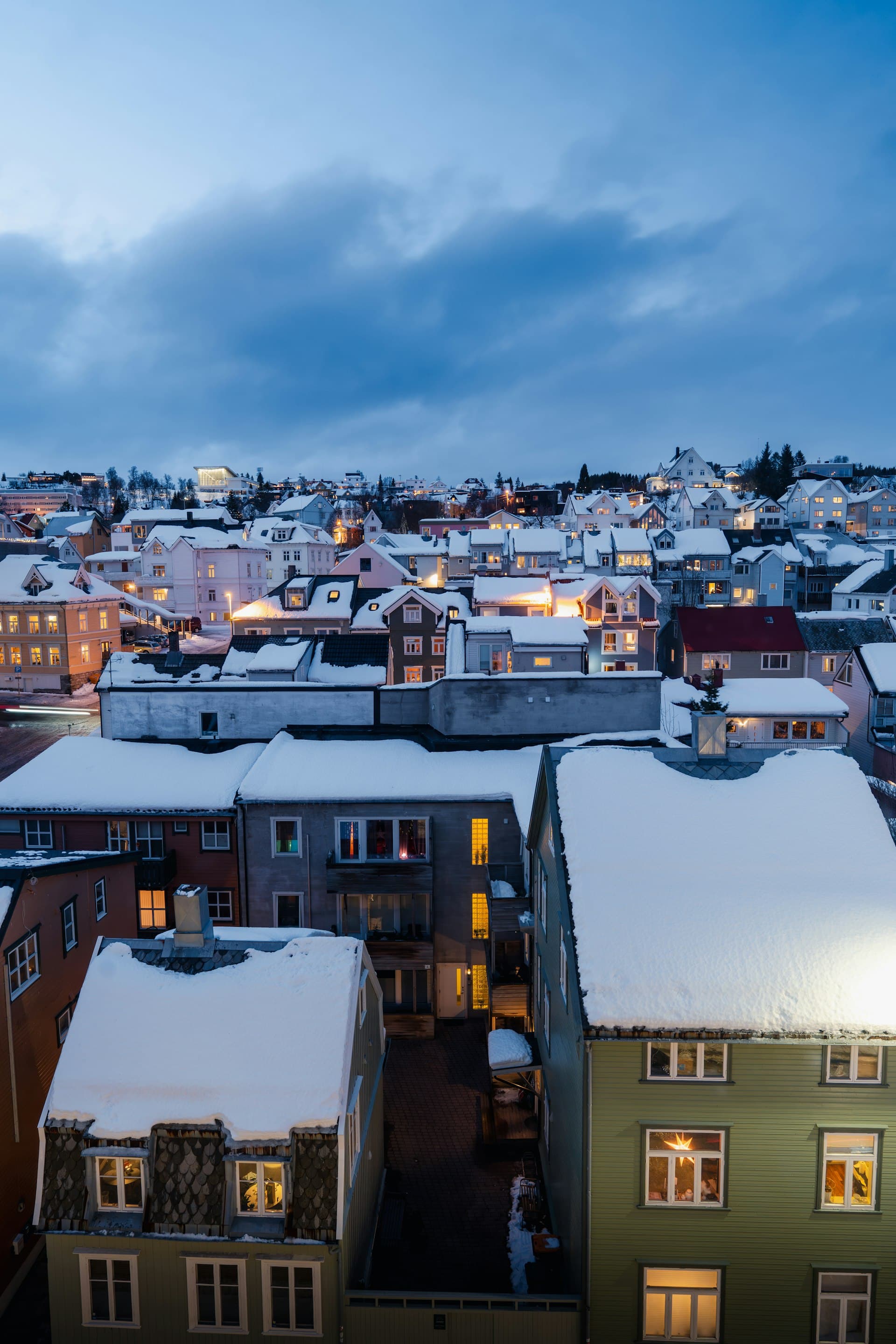 Snow-covered rooftops in residential neighborhood at winter dusk