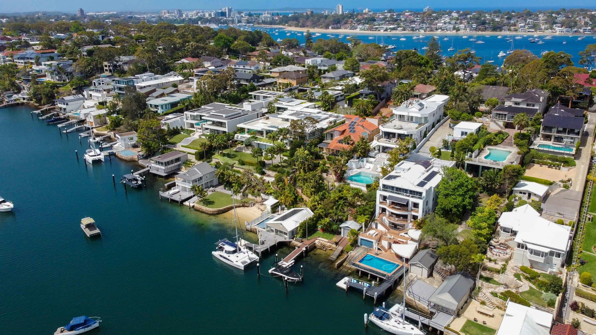 Aerial view of waterfront homes with boats and docks in coastal Florida neighborhood